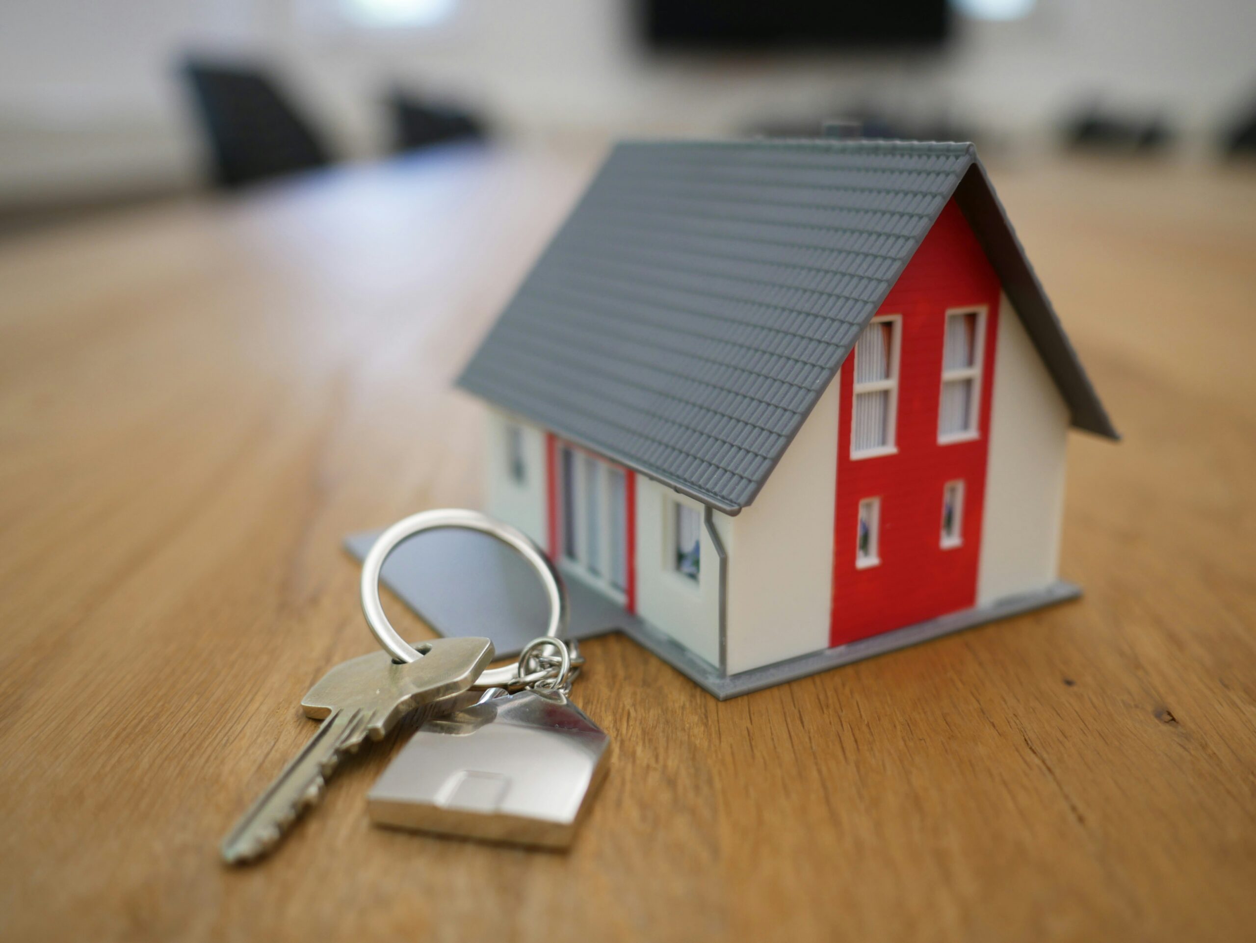 Toy house on table with a set of keys beside it